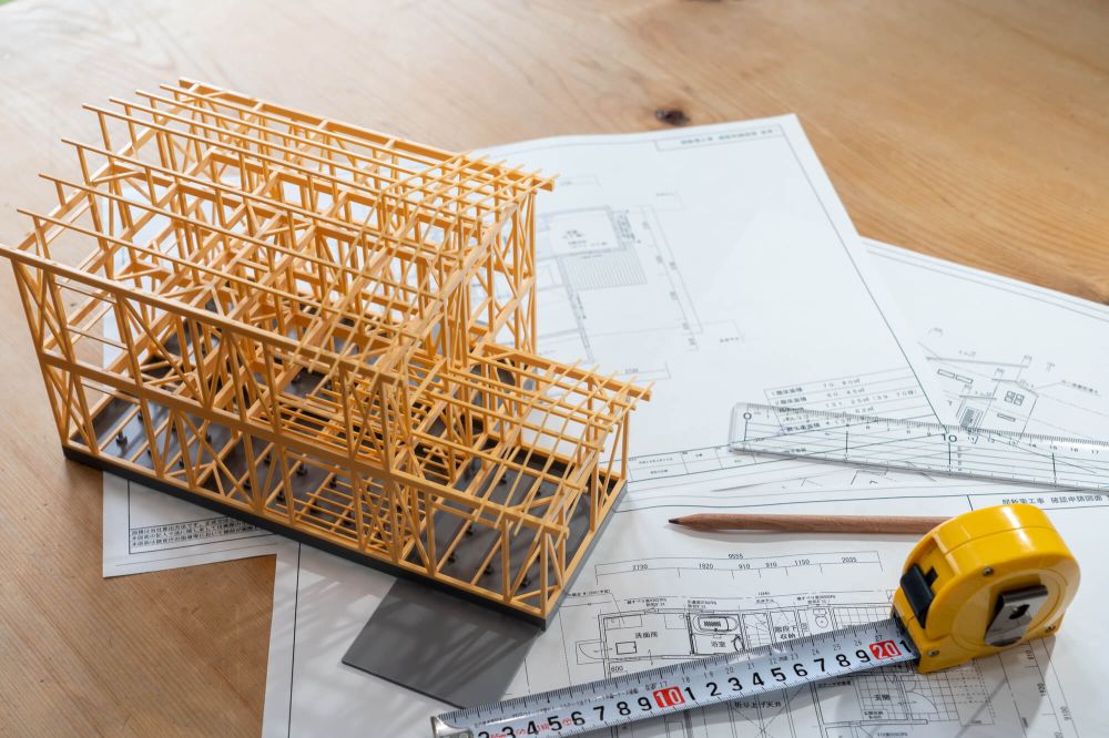 床面積の確認をイメージする住宅の建築模型と設計図
